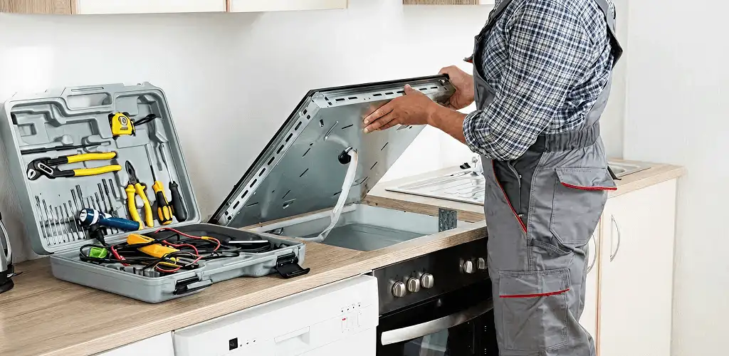 Handyman repairing a cooktop and checking wiring connections in Jersey City, NJ