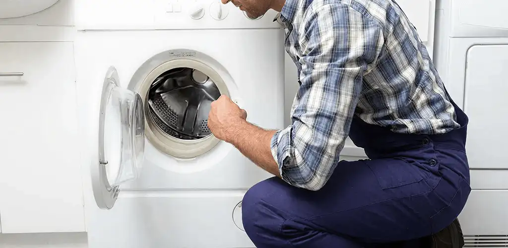 Handyman inspecting a dryer drum and internal parts for repair in Jersey City, NJ