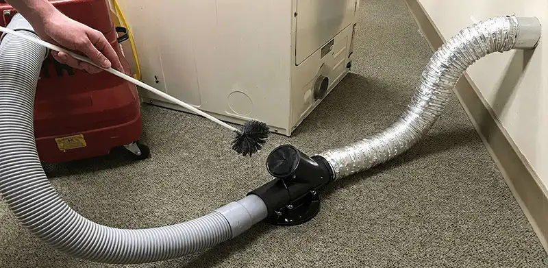 Dryer vent cleaning service removing lint from a dryer duct connection in Jersey City, NJ