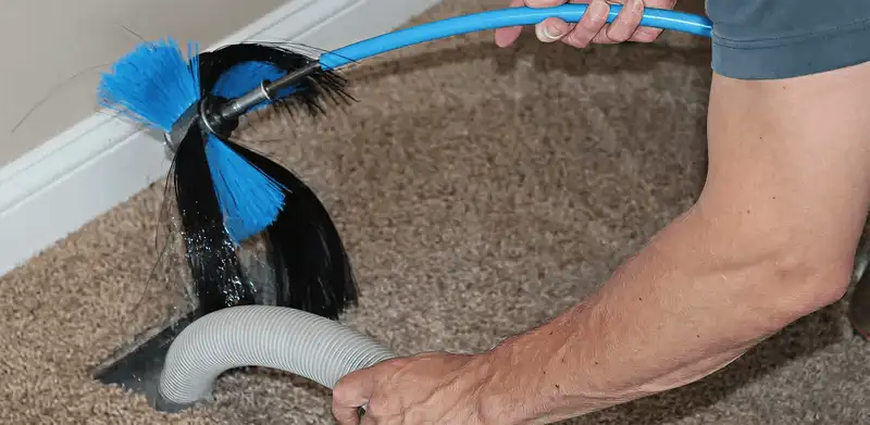 Dryer vent cleaning technician brushing lint from a vent line in Jersey City, NJ