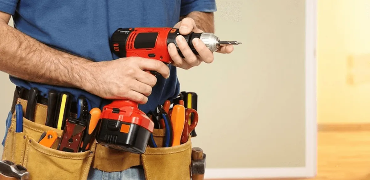 Handyman holding a power drill for home repairs and installations in Jersey City, NJ