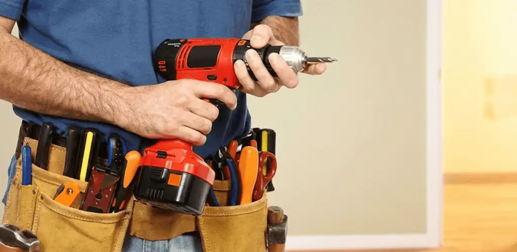 Handyman holding a power drill for home repairs and installations in Jersey City, NJ